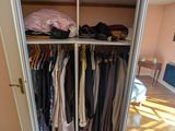 une armoire avec beaucoup de vêtements suspendus dedans