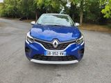 the front end of a blue car parked on a street