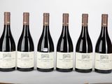 six bouteilles de vin sont alignées sur une table