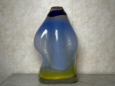 un vase bleu et jaune posé sur une table