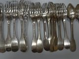 many forks and spoons lined up on a table