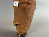 a clay sculpture of a face with a tag on it
