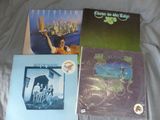 three albums of various music on a bed with a white sheet