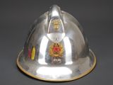 silver helmet with red and gold decorations on it on a gray surface